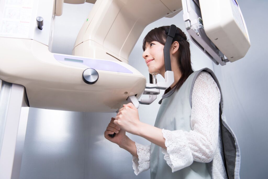 歯医者でレントゲンを受ける女性