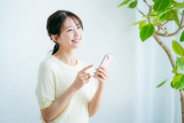 AdobeStock_1174521411 (3) スマートフォンで検索する女性のイメージ