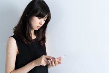 スマートフォンでボツリヌストキシン治療を検索する女性